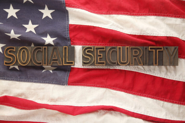 the words social security in old letterpress wood type on an American flag