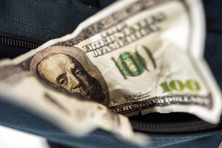 Crumpled money in your pocket. Banknote peeks out of pocket. A hundred dollars peeps out of the bag. old banknote. Concept - cash loss. Worn out money. Concept - the inconvenience of using cash.