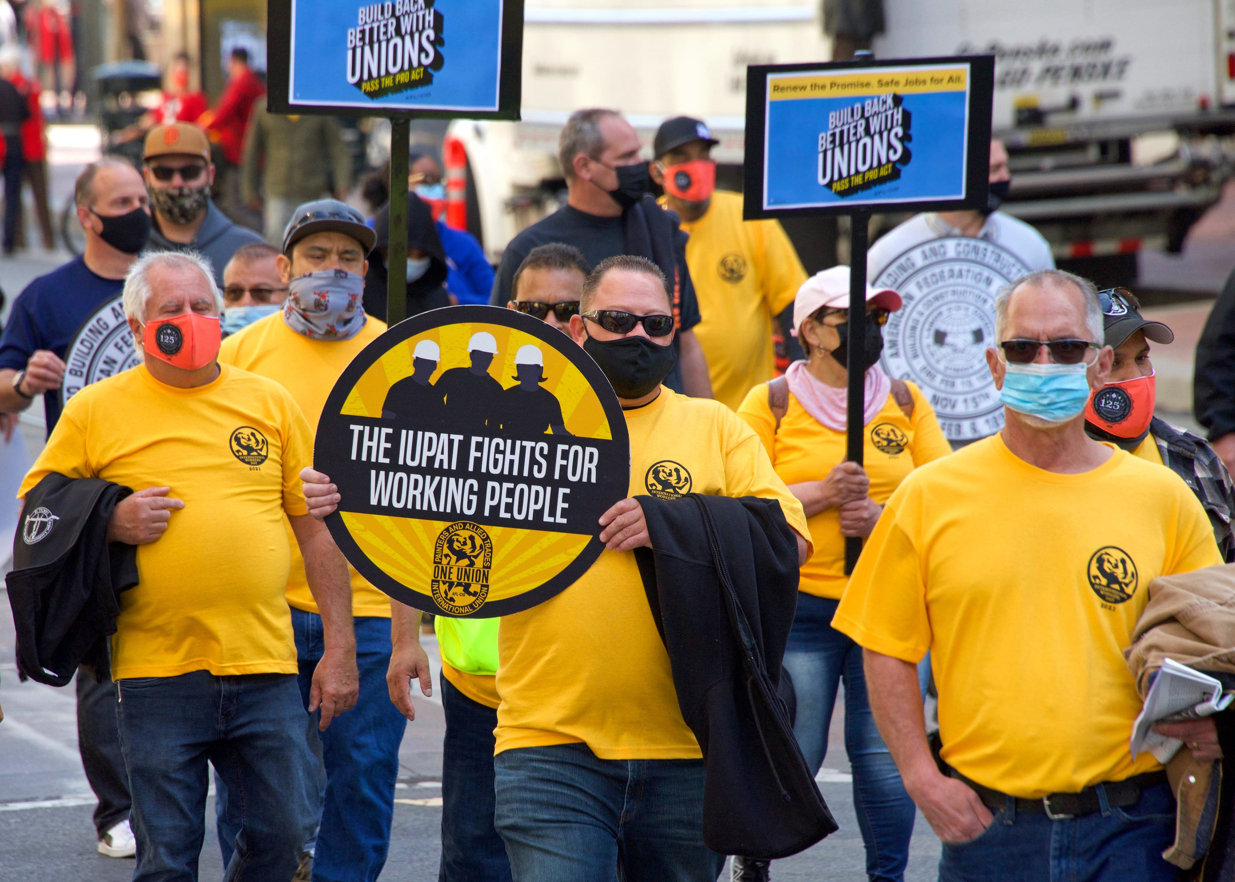 San Francisco, CA - May 1, 2021: Unidentified participants marching up Market Street celebrating May Day, also known as International WorkersaEUR(TM) Day.