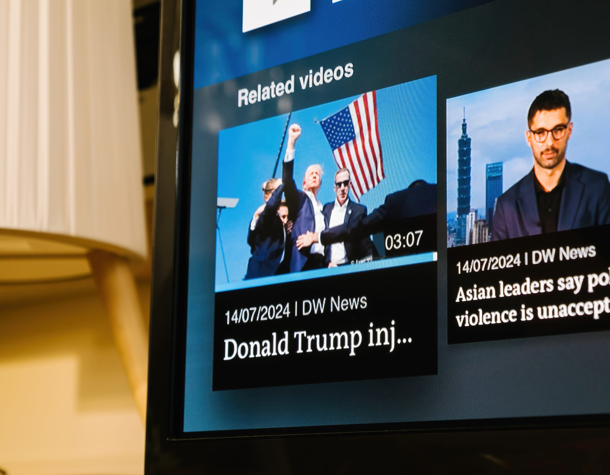 London, UK - Jul 14, 2024: Living room TV with German channel broadcasts live breaking images of an attempted assassination, showing Trump raising his fist and projecting a characteristic image of defiance