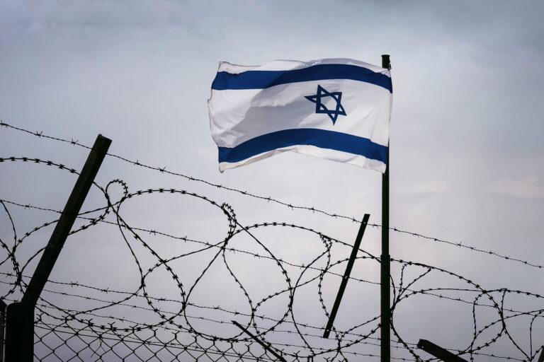 The concept of sanctions pressure on the israel government. Jewish flag in barbed wire, Sanctions pressure and aggression of Israel. The wall on the border of Israel and Syria
