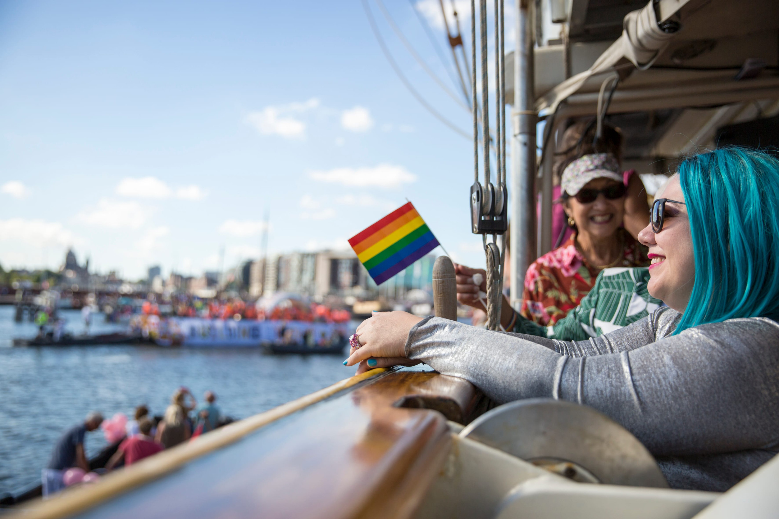 Amsterdam, the Netherlands - August 06, 2016: woman with blue hair watching the annual event for protection of human rights and civil equality , Gay Pride Parade on the canals during Euro Pride 2016