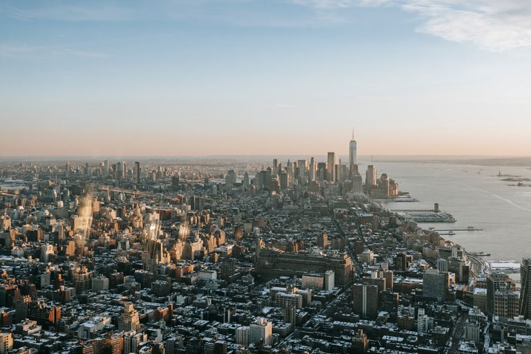 Drone view of modern megapolis with high office towers and multistory buildings located on coast of bay in New York