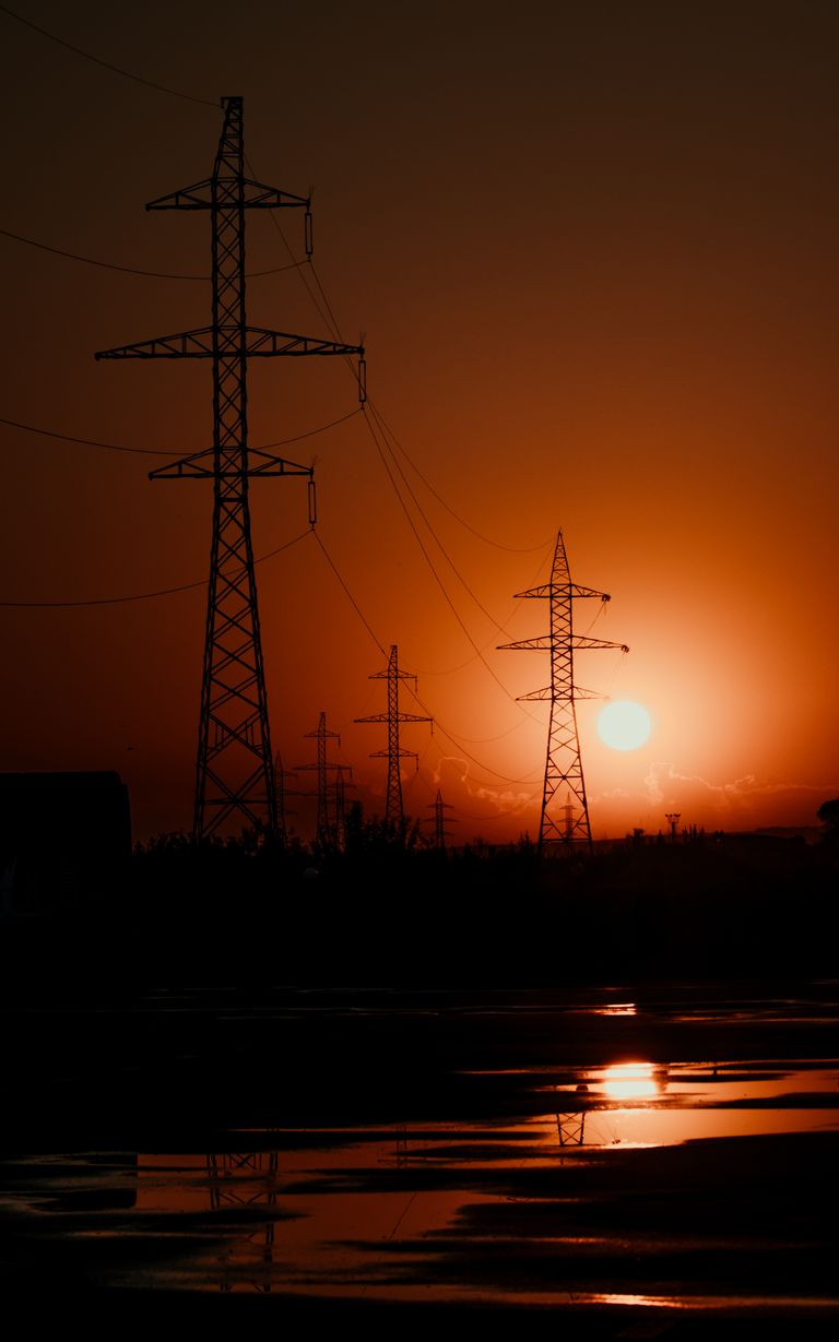 Silhouetted power lines against a vivid sunset creating a striking contrast.