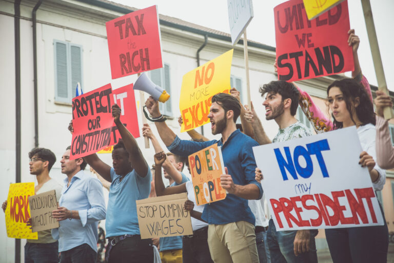 Public demonstration on the street against social problems and human rights. Group of multiethnic people making public protest