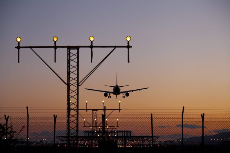 Plane landing on the runway at dusk