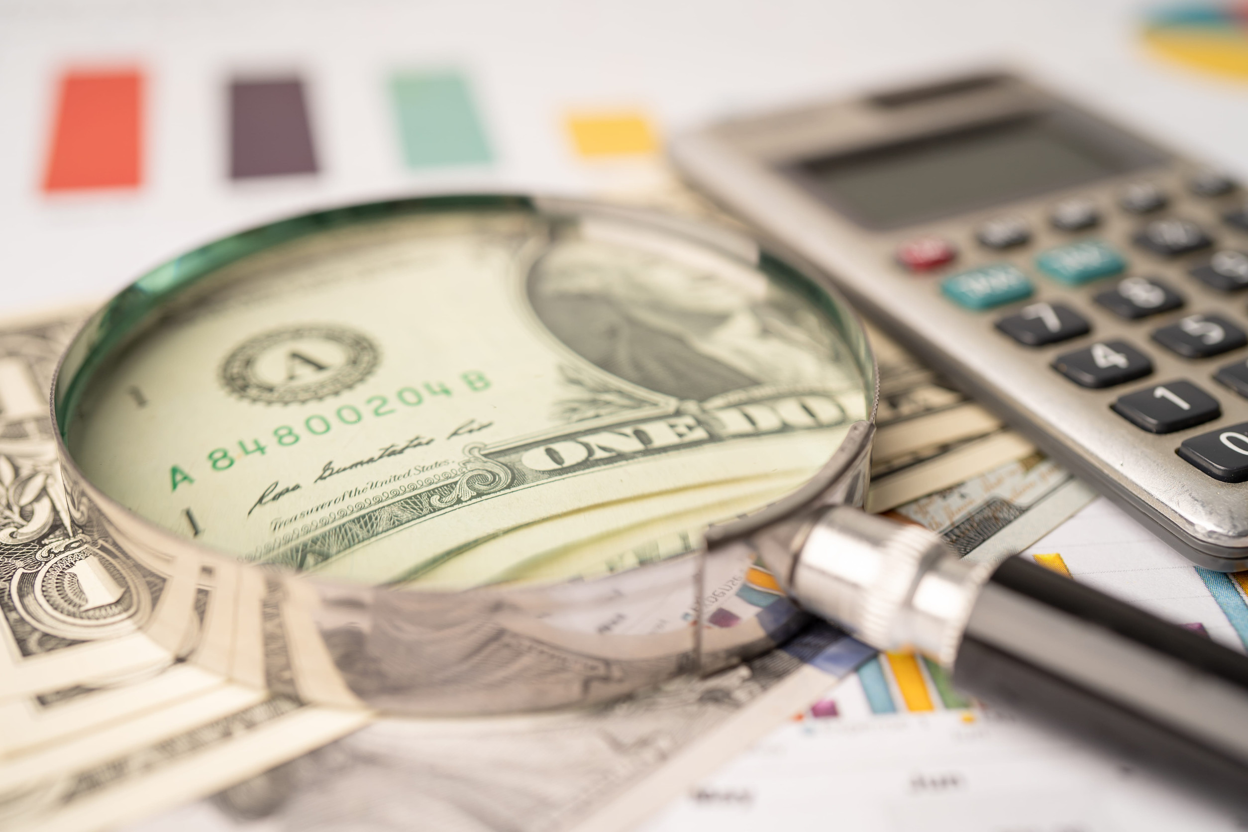 Magnifying glass and US dollar banknotes on graph background, Banking Account, Investment Analytic research data economy, trading, Business company concept.