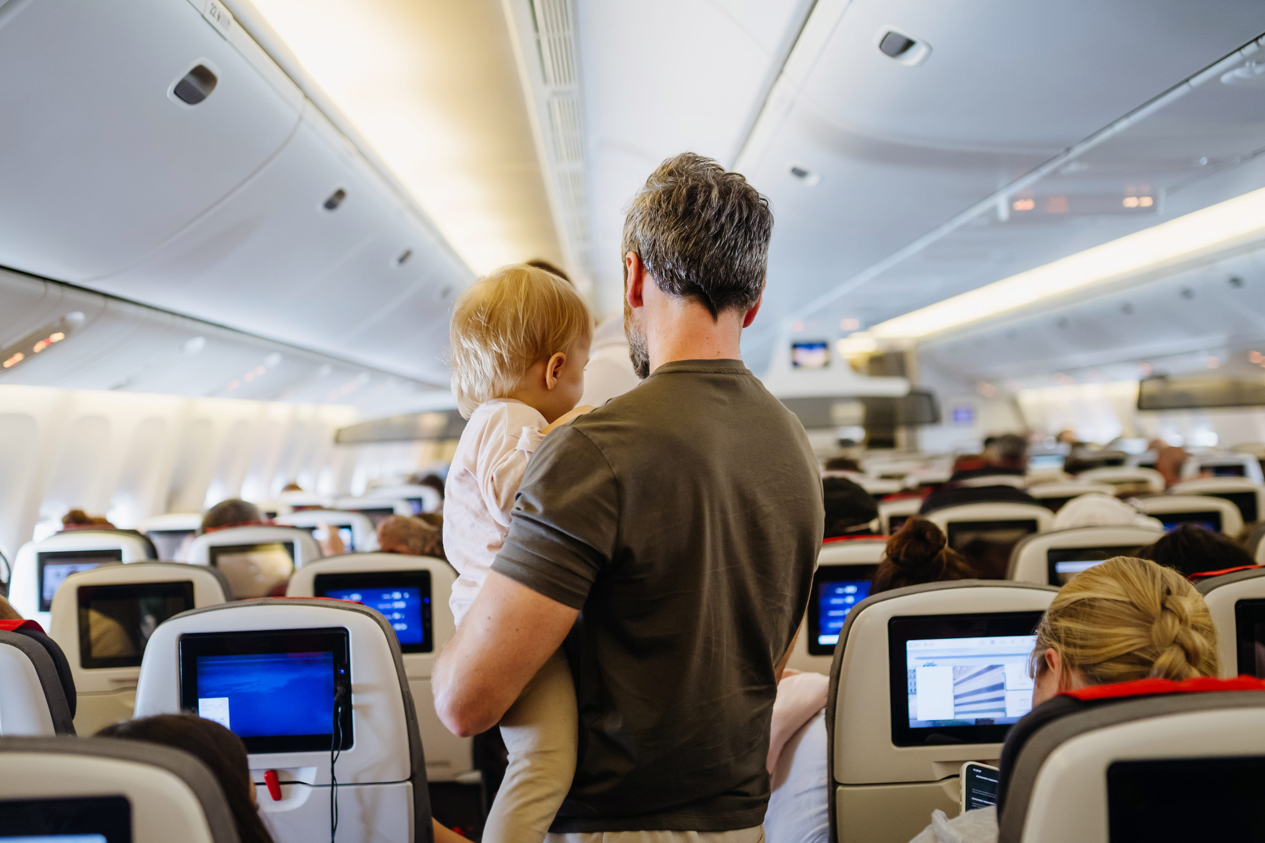 Father takign care of toddler during family flight.