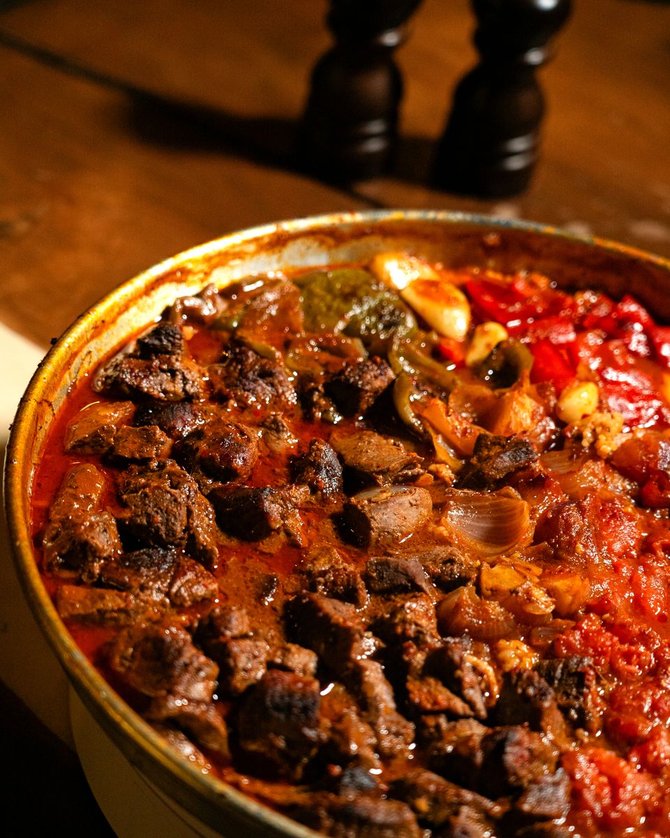 Close-up of a flavorful Moroccan tagine with roasted vegetables and spices, perfect for culinary enthusiasts.