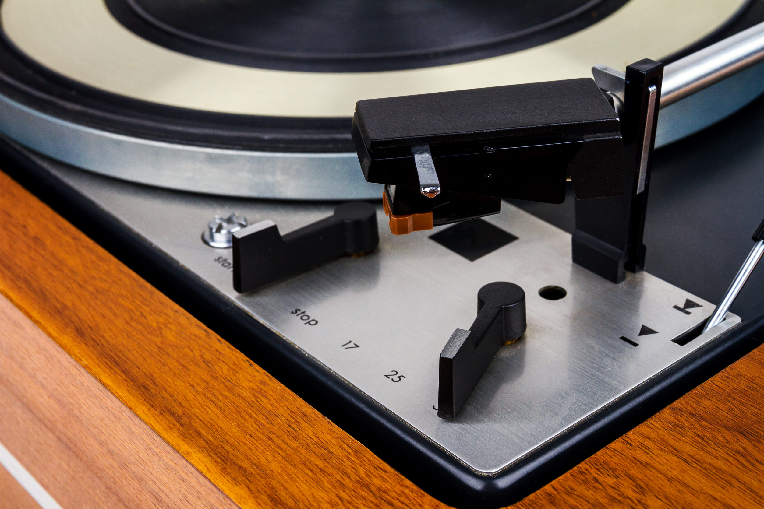 Close up of vintage turntable vinyl record player. Wooden plinth. Retro audio equipment.