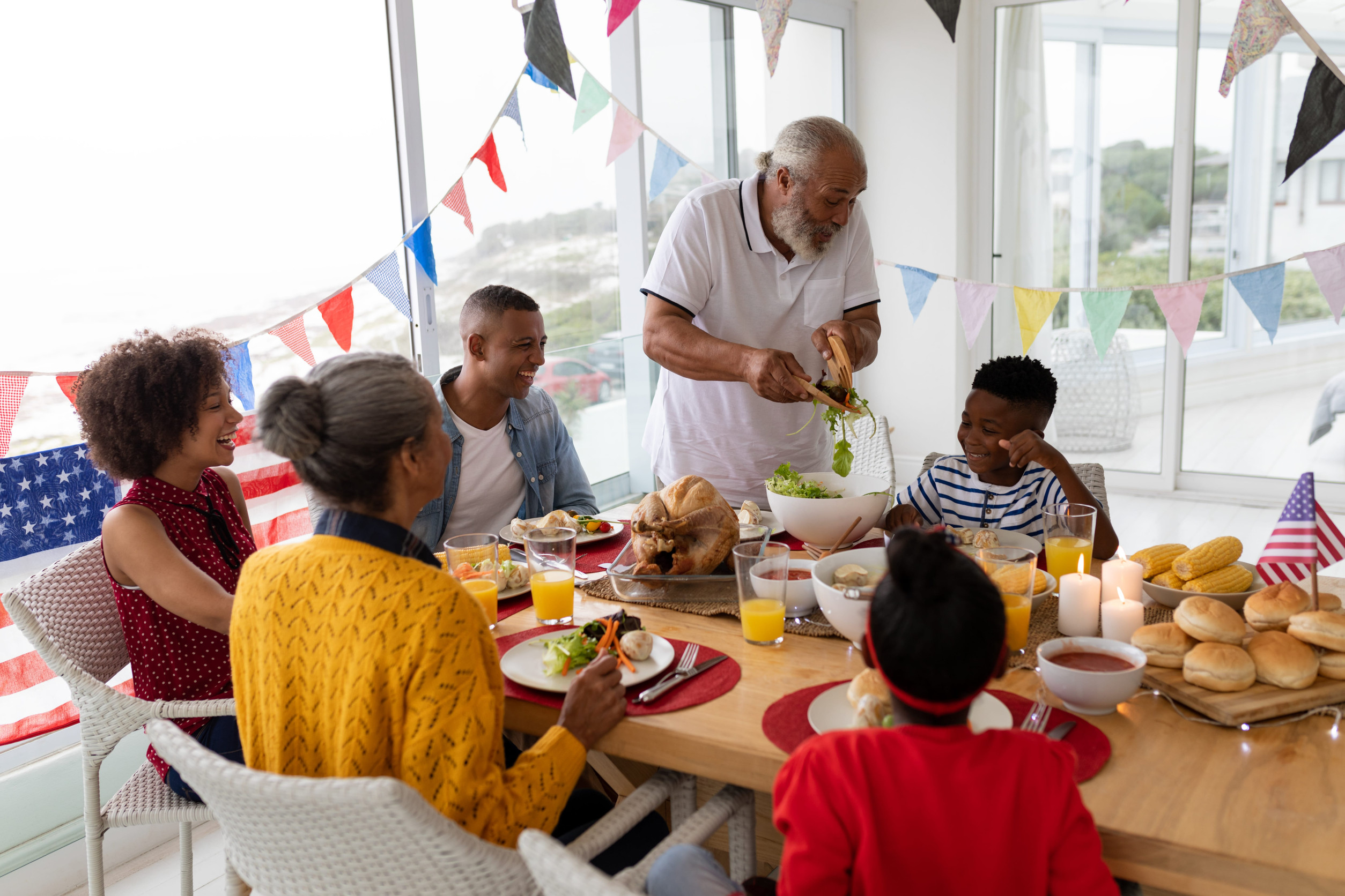 Side view of Multi-generation African American family having meal on a dining table at home