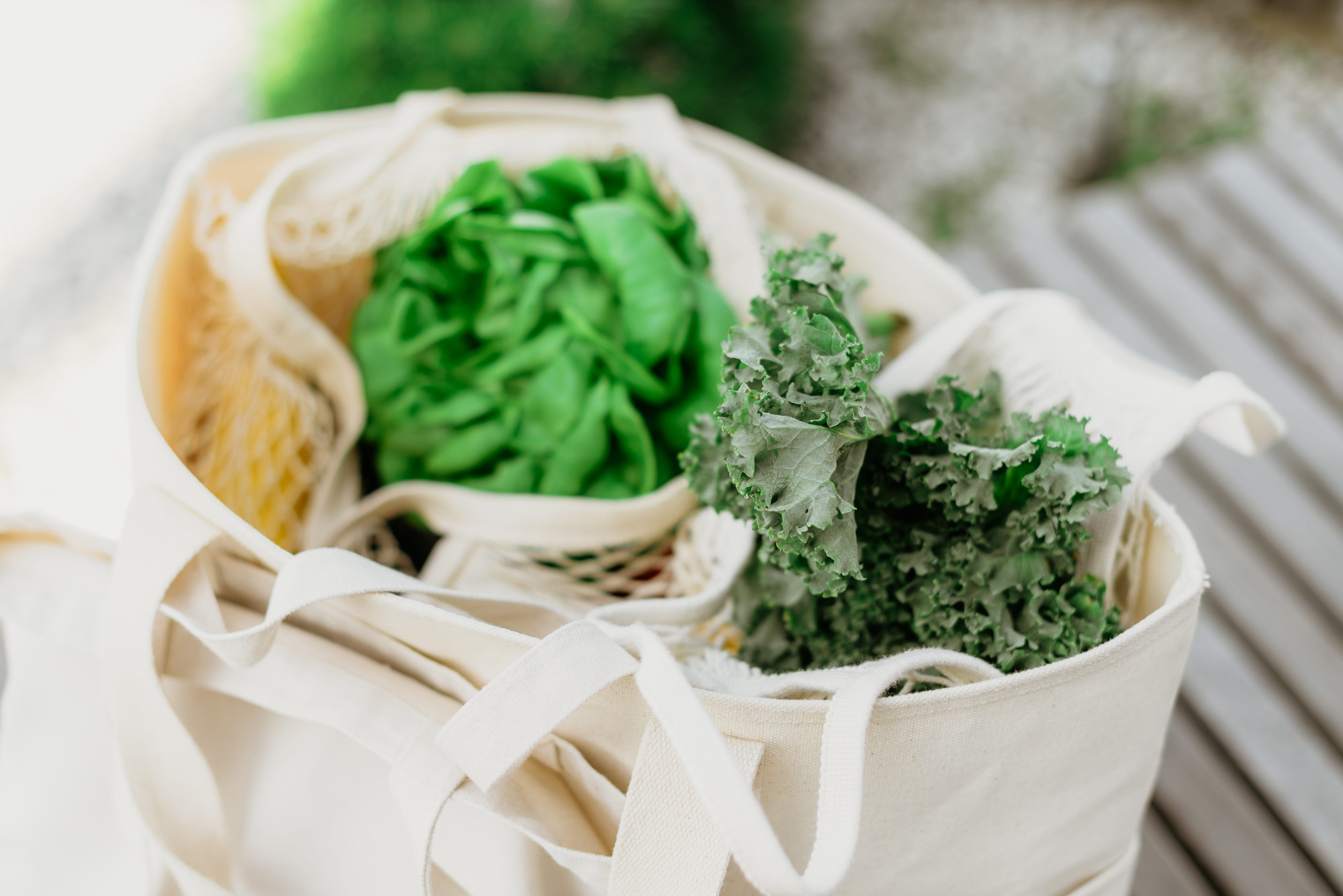 Eco friendly mesh bag with organic green vegetables. Flat lay, top view. Zero waste, plastic free concept. Healthy clean eating diet and detox