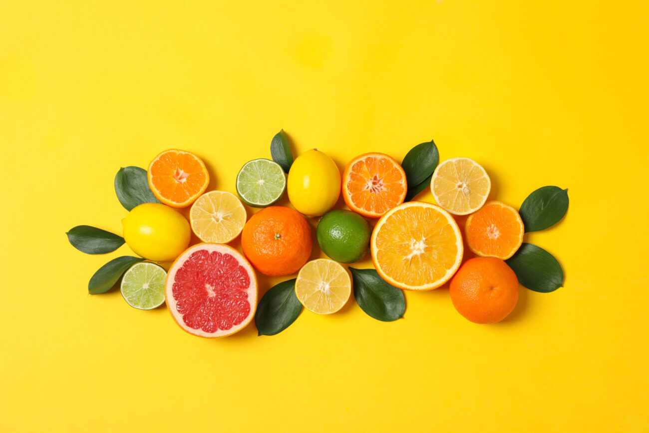 A vibrant array of citrus fruits arranged artfully against a cheerful yellow background, showcasing the refreshing and zesty nature of oranges, lemons, and grapefruits, perfect for a summer gathering. Image Credit: atlasfoto/ 123RF