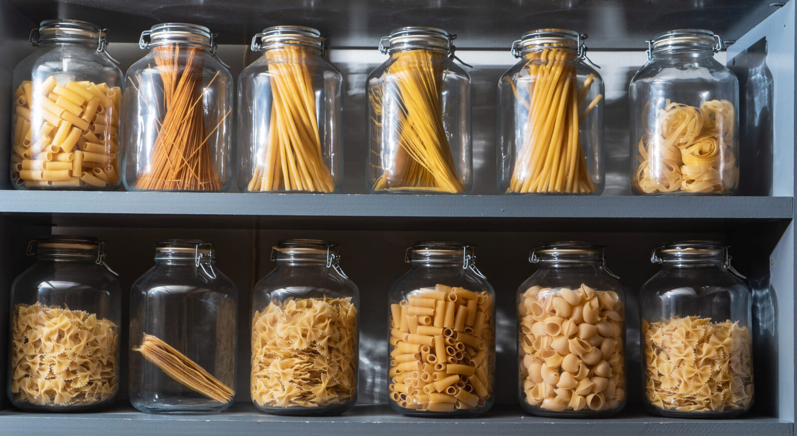 A delightful array of pasta variety beautifully organized in glass jars, showcasing the rich textures and colors of each type. From delicate capellini to robust penne, this culinary collection invites any chef to explore and create savory dishes. Image Credit: maxsheb/ 123RF