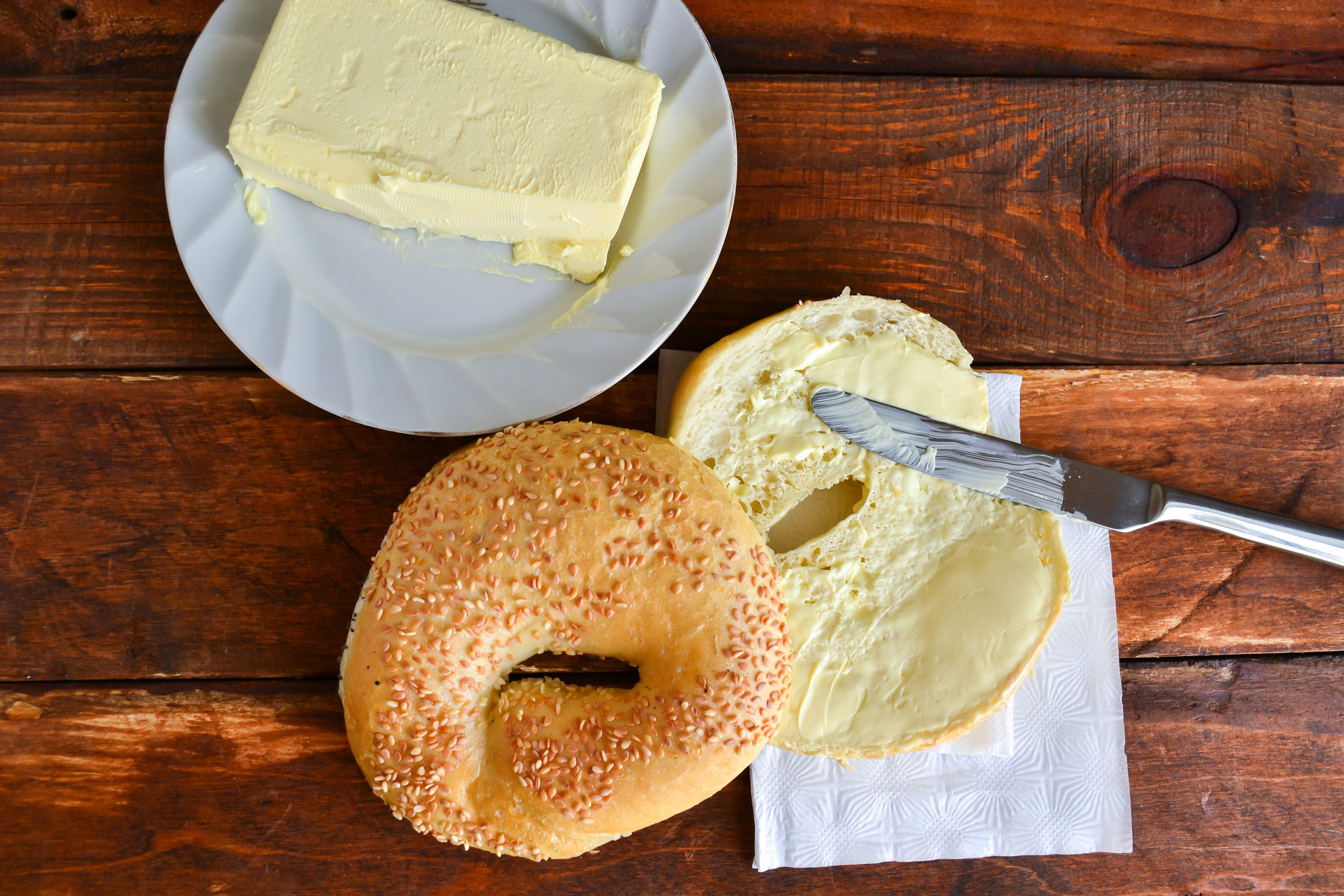 sweet bun with sesame, butter, buttered bread, knife