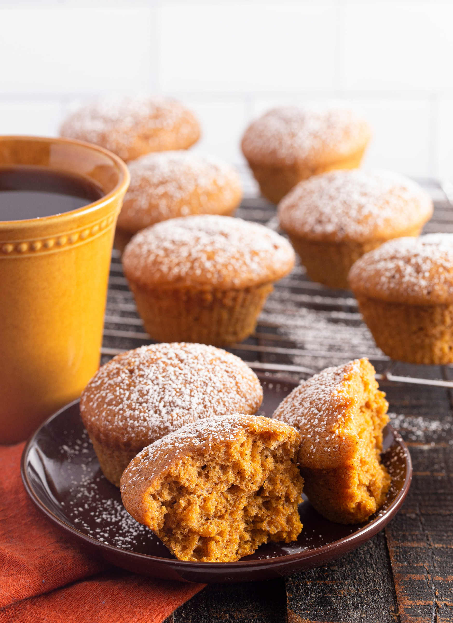 Pumpkin Spice Muffins Topped with Powdered Sugar on a Rustic Wooden Table