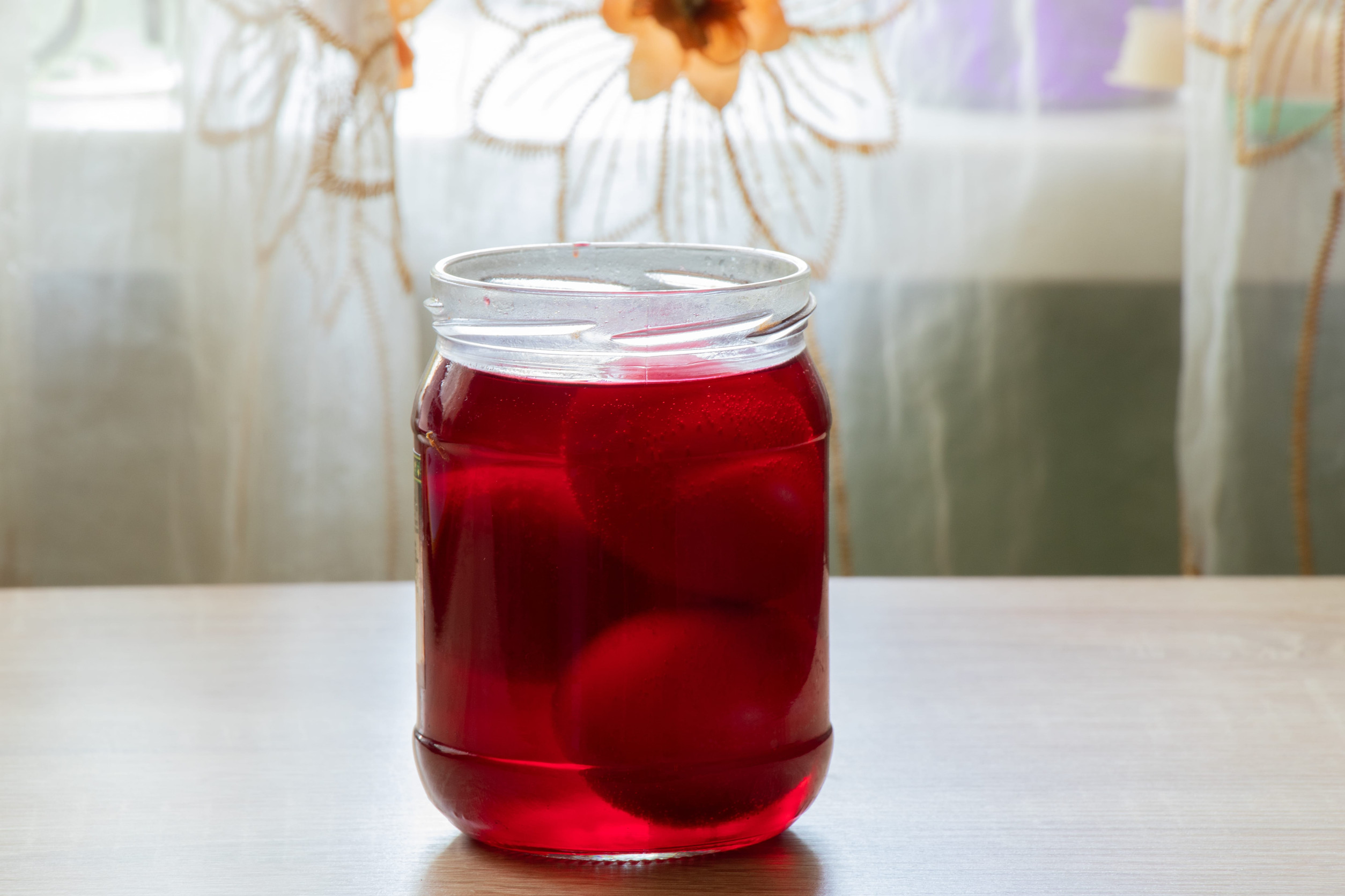 jar with red paint and eggs in it, preparation for Easter coloring