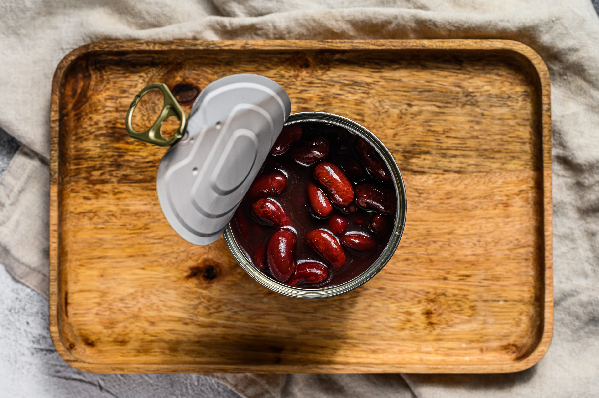 Red canned beans in an aluminum can. Gray background. Top view.
