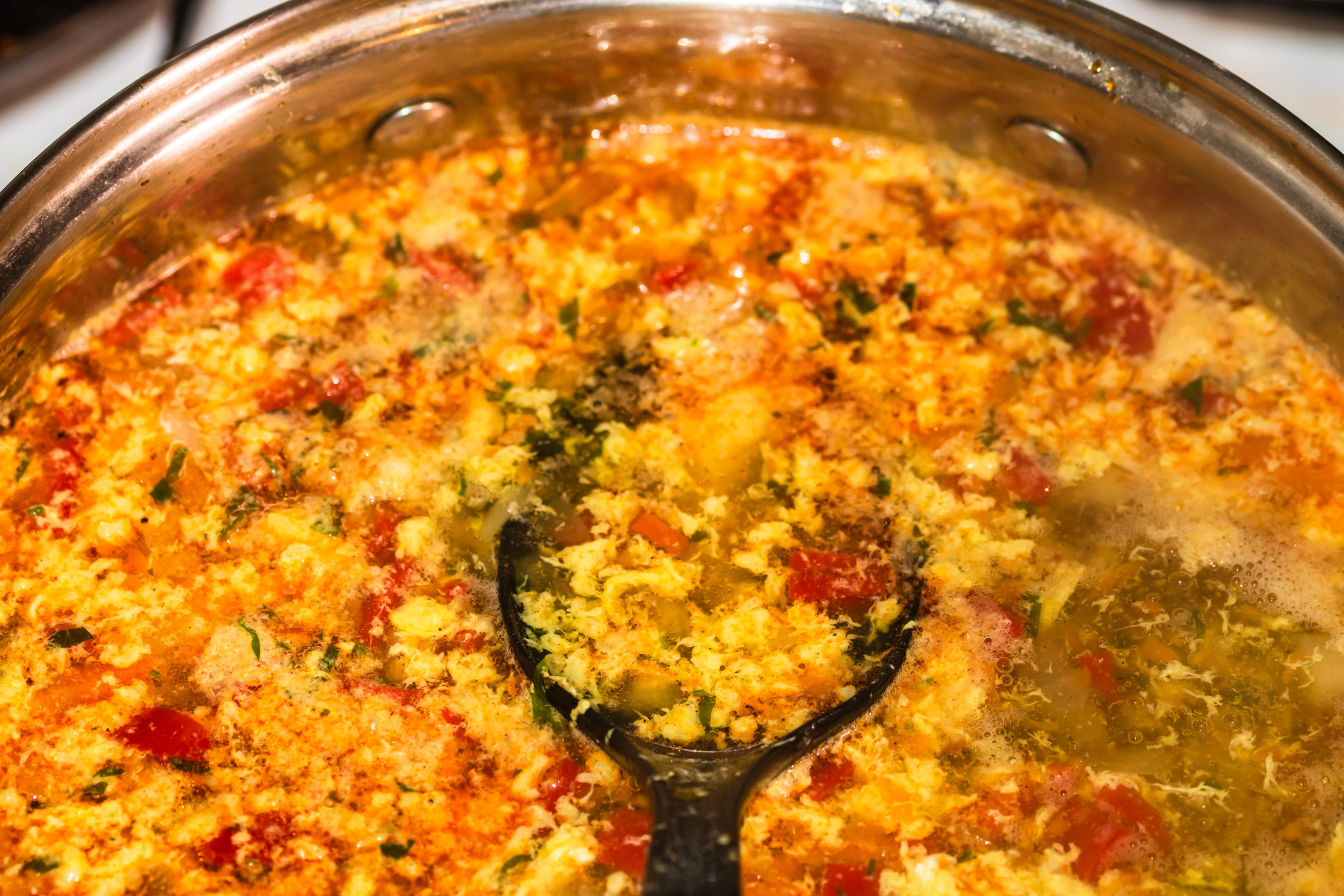 Preparation of soup with chicken and vegetables. Close up of boiling soup.
