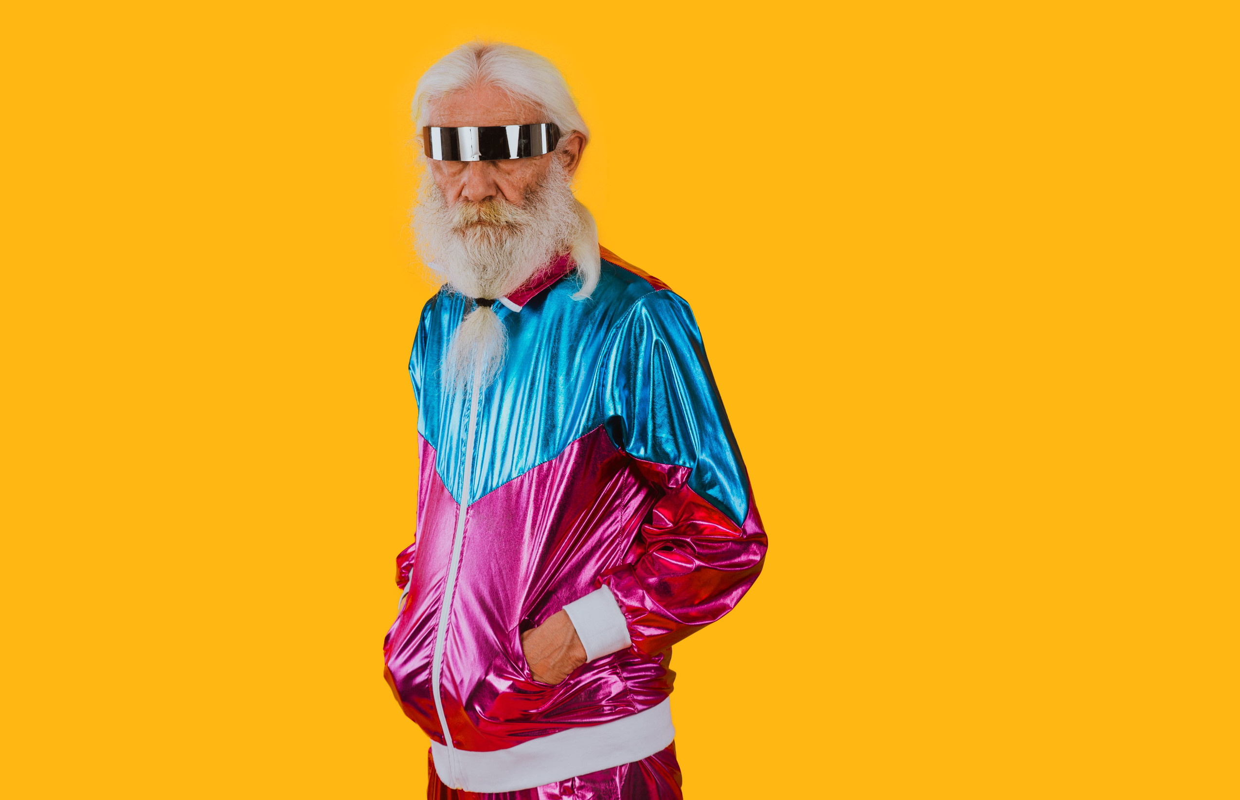 Fashionable grandfather posing with funny futuristic clothes. Senior man portraits on colored background