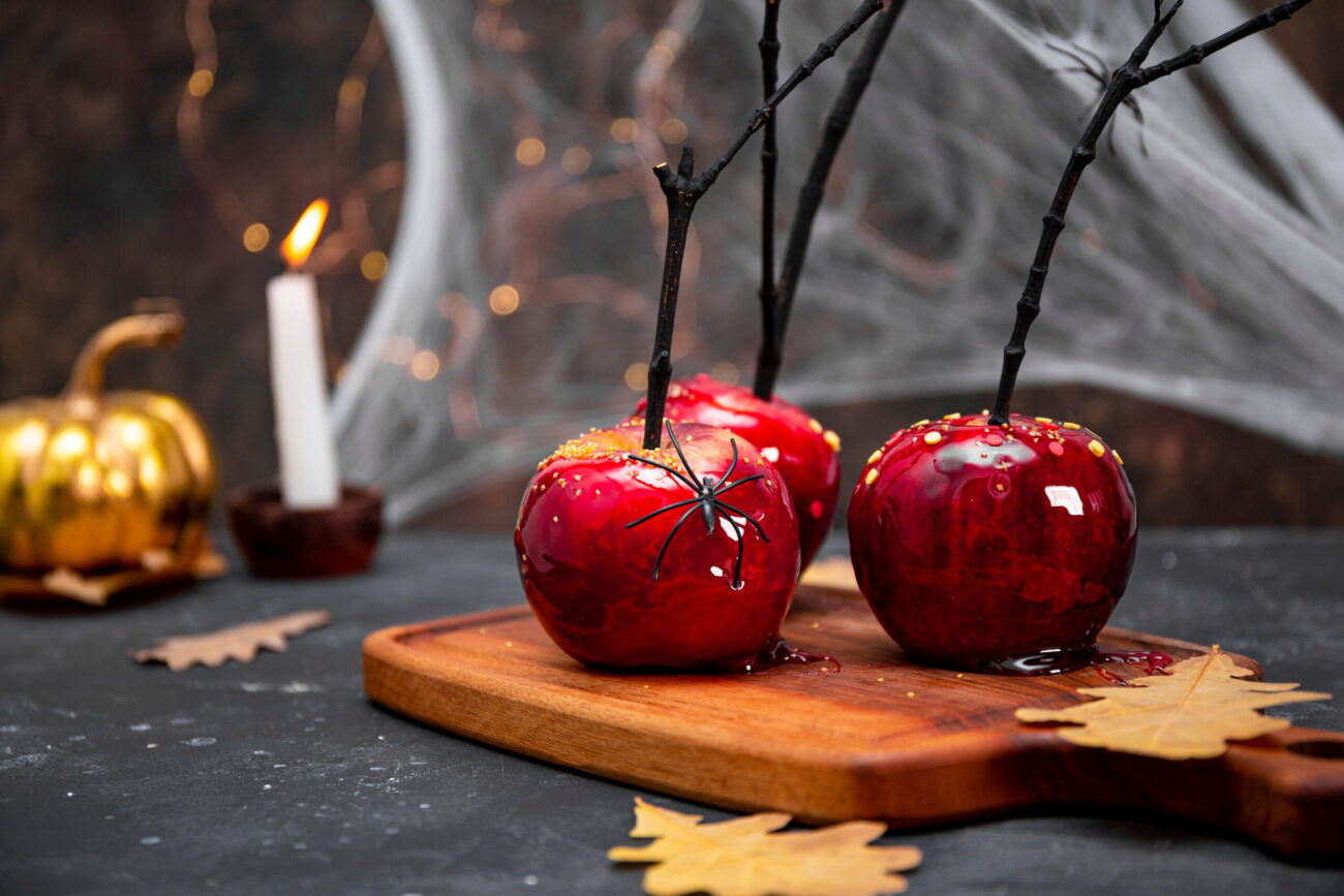 A hauntingly delicious display of caramel apples, adorned with spooky decorations and set against a backdrop of autumn leaves and eerie candlelight. Perfect for a Halloween gathering, these treats add a sinister yet sweet touch to the festivities. Image Credit: braxma/ 123RF