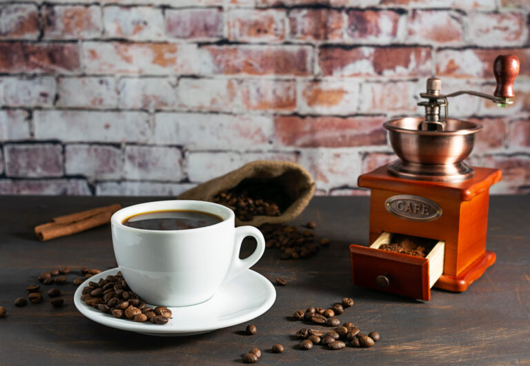 A cozy coffee moment captures the rich aroma of freshly brewed coffee, surrounded by roasted beans and a vintage coffee grinder. Cinnamon sticks add a touch of warmth, inviting you to savor each sip in a comforting atmosphere. Image Credit: annarosa84/ 123RF