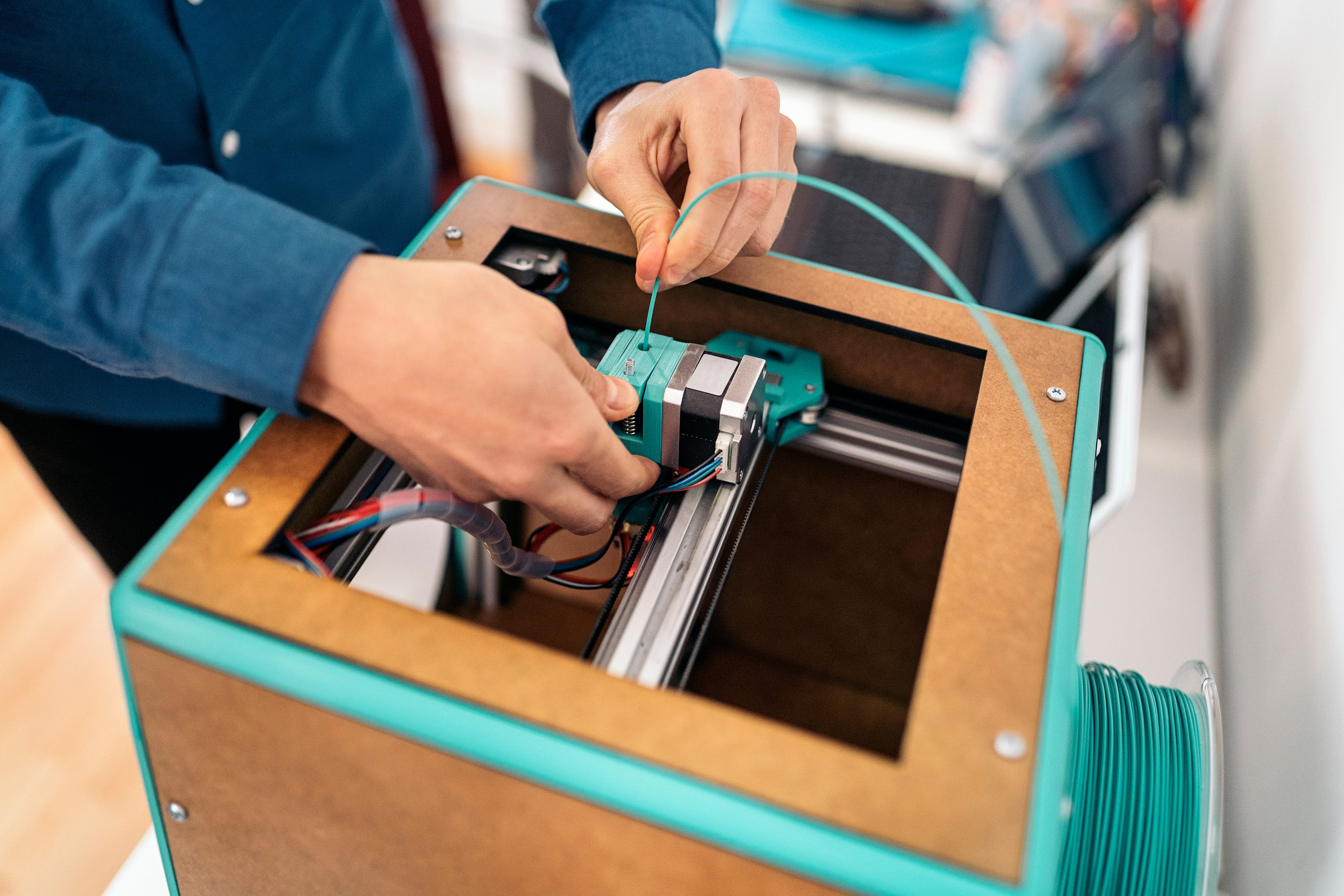 Stock photo of unrecognized technician fixing modern 3d printer.