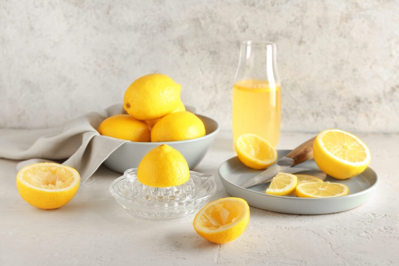 A glass bottle of lemon juice adds a touch of summer, while the soft backdrop enhances the natural brightness of these citrus delights. Image Credit: serezniy/ 123RF