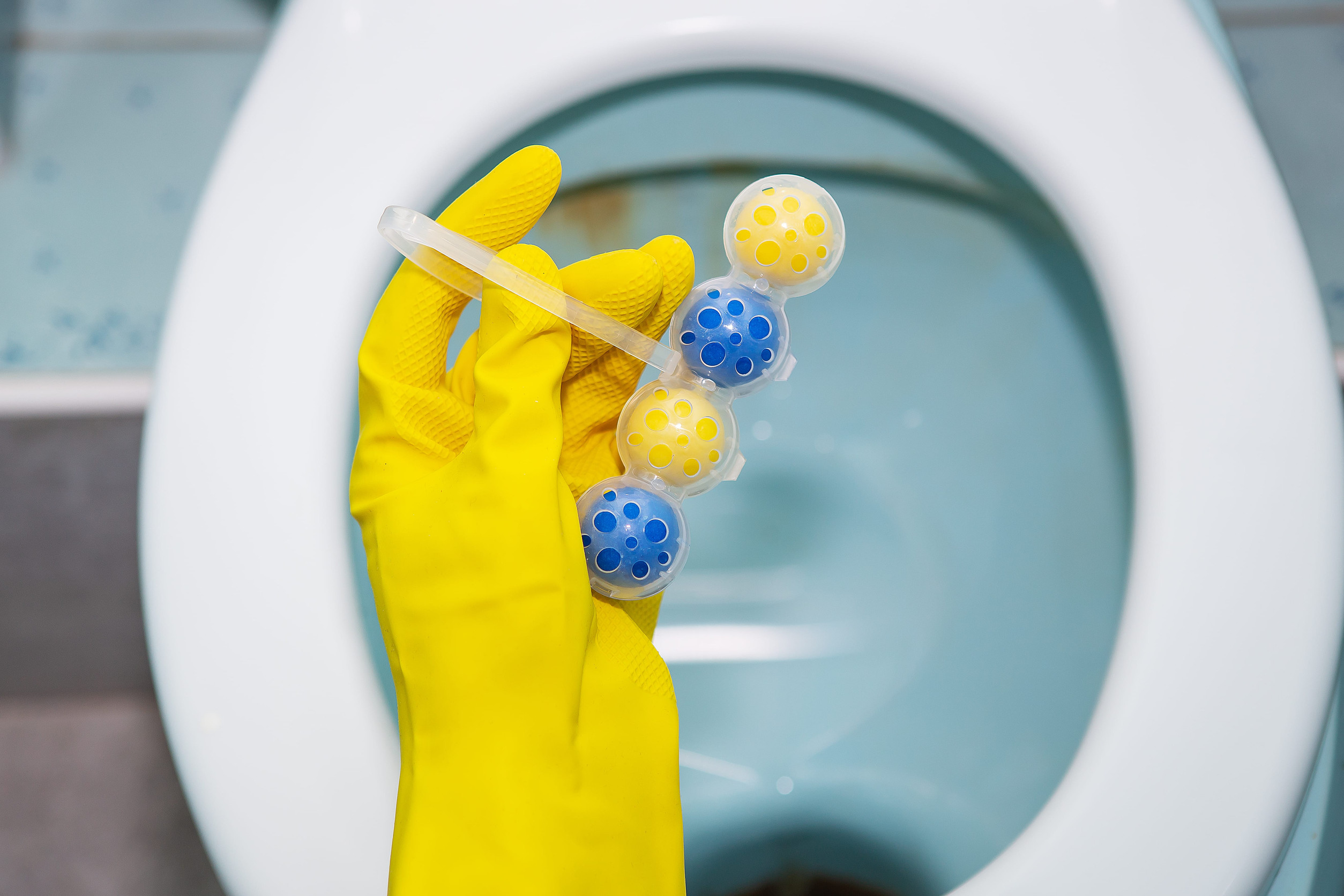 A yellow-blue plastic toilet block that cleans the walls of the toilet and refreshes the bathroom