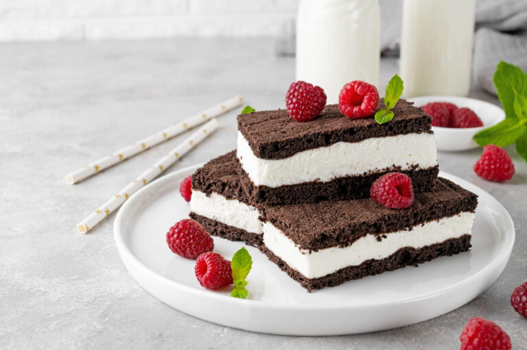 Indulge in a delightful treat with layers of rich brownies and velvety cream, topped with fresh raspberries and mint. Perfect for summer gatherings or a cozy dessert at home. Image Credit: irina2511/ 123RF
