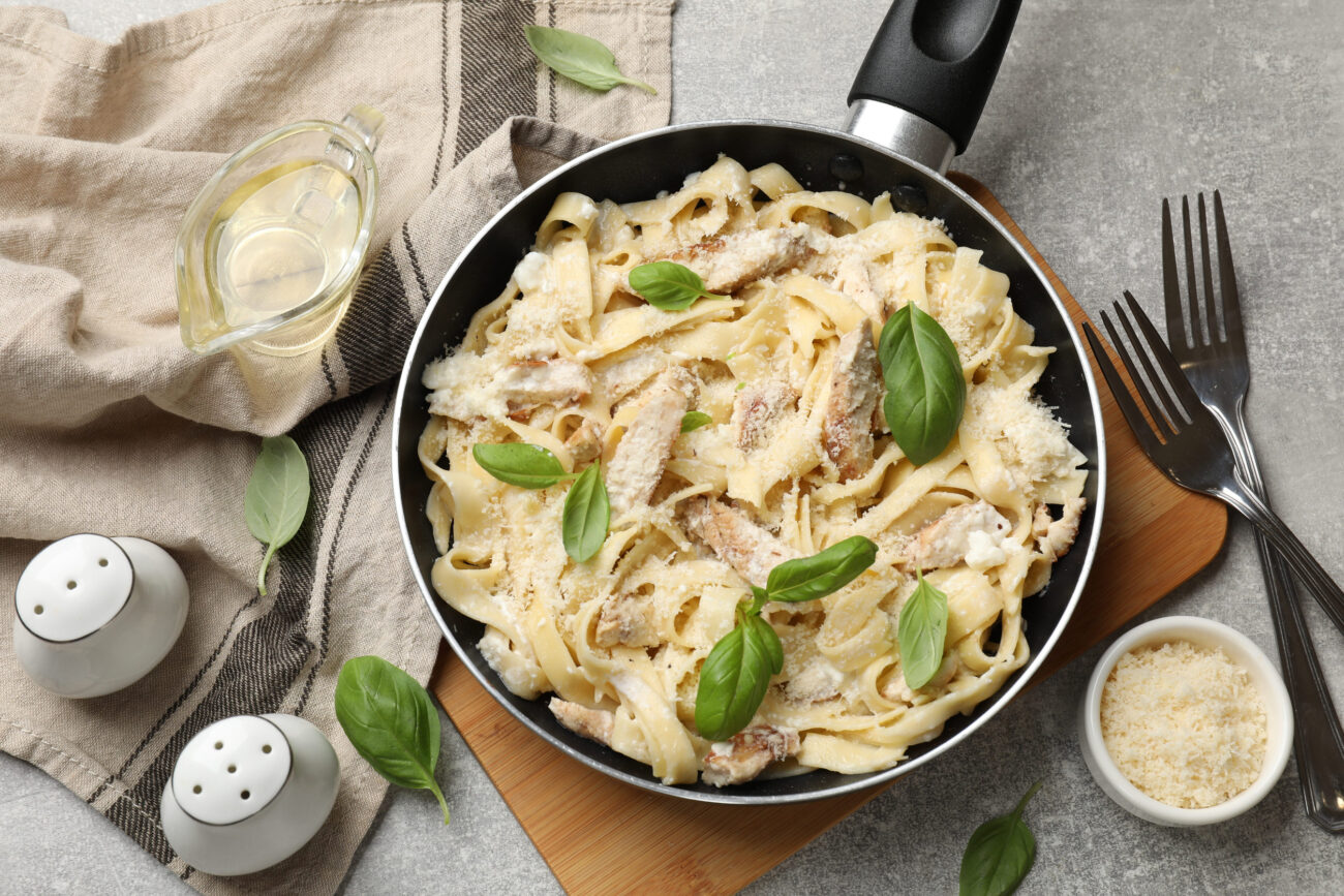 Delicious pasta Alfredo with chicken served on grey table. Image Credit: liudmilachernetska/ 123RF