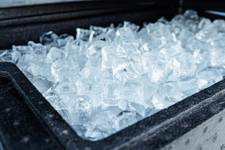 A close-up view of a container filled with clear ice cubes, showing their frozen texture and cold freshness. Image Credit: micheleursi/ 123RF