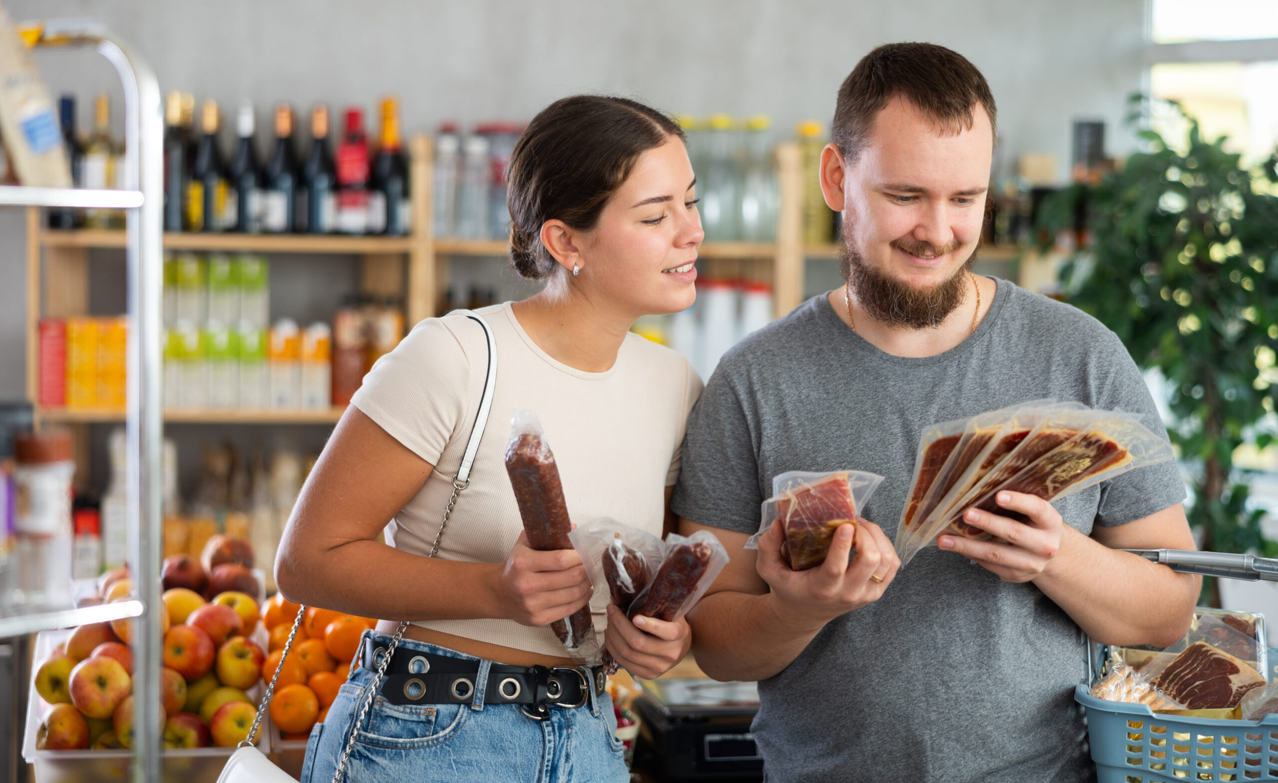Spouses looking at hamon and dried sausage in store