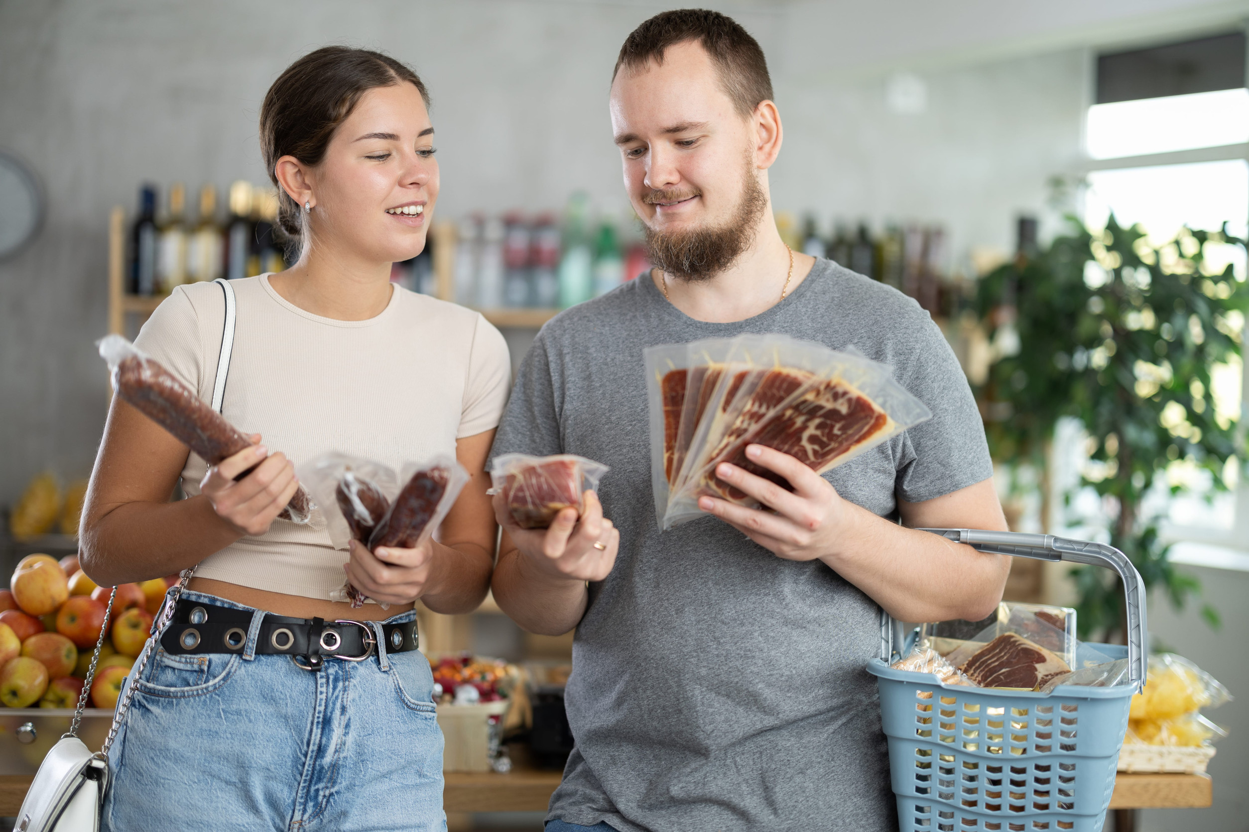 Spouses looking at hamon and dried sausage in store