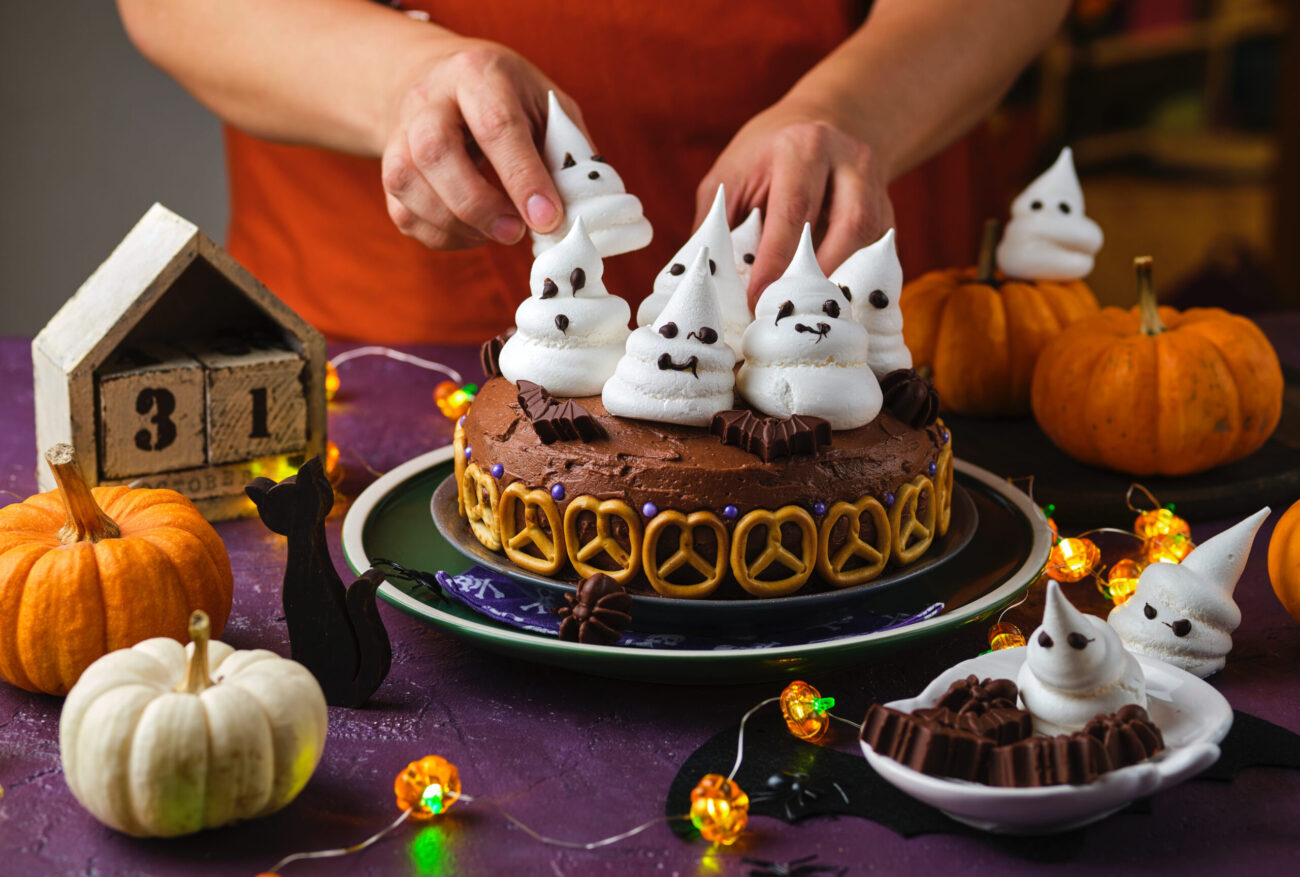 Halloween sweets, pumpkin cream cake decoration with meringue ghosts on a purple background. Image Credit: Halloween sweets, pumpkin cream cake decoration with meringue ghosts on a purple background. Image Credit: natallyanaumava/ 123RF