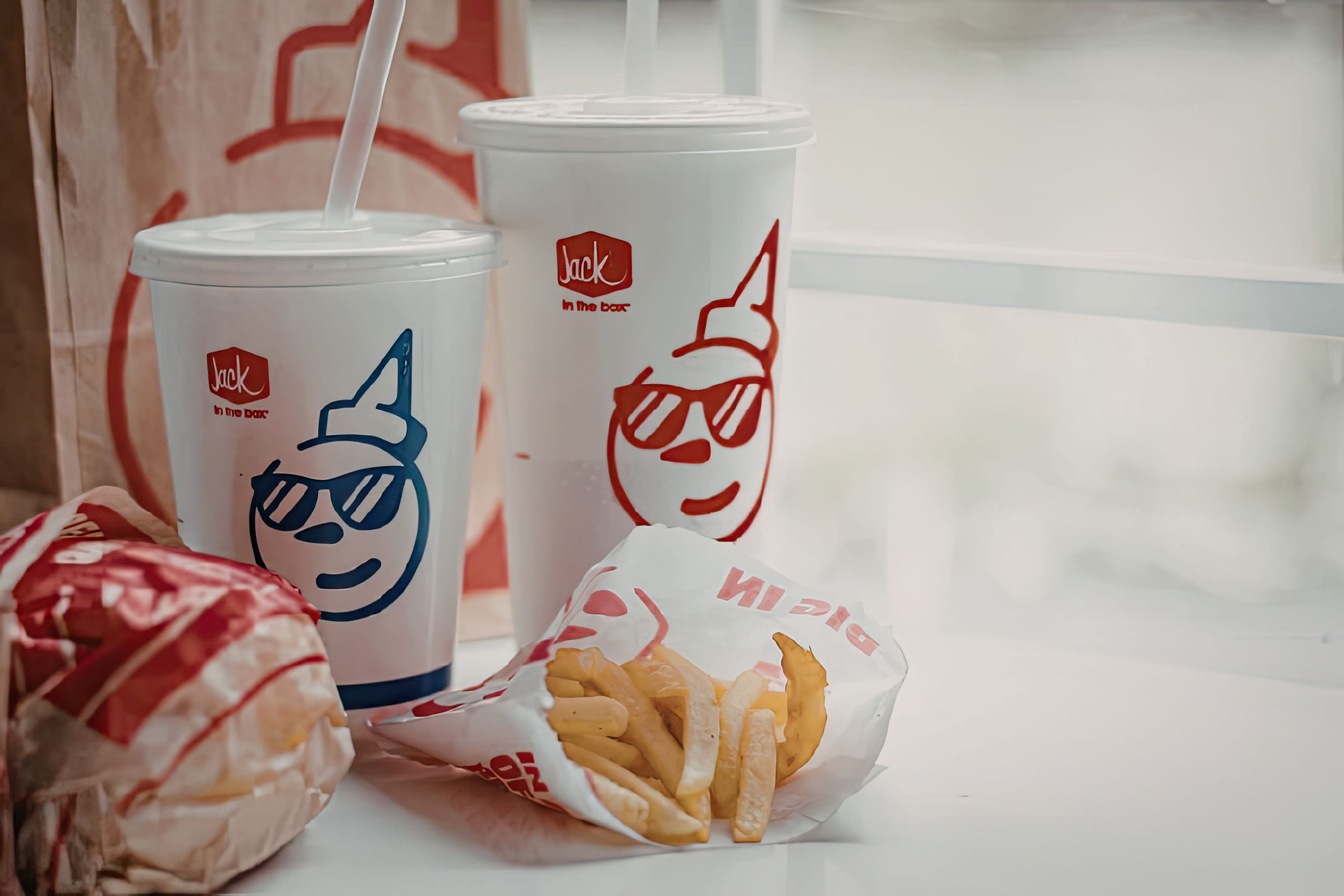 A fast food meal consisting of a burger, fries, and drinks from a restaurant.