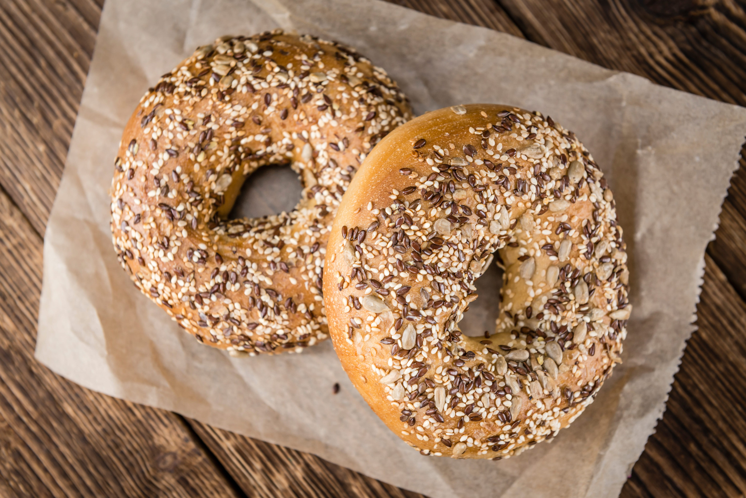 Wholemeal Bagels (selective focus; detailed close-up shot) on wooden background