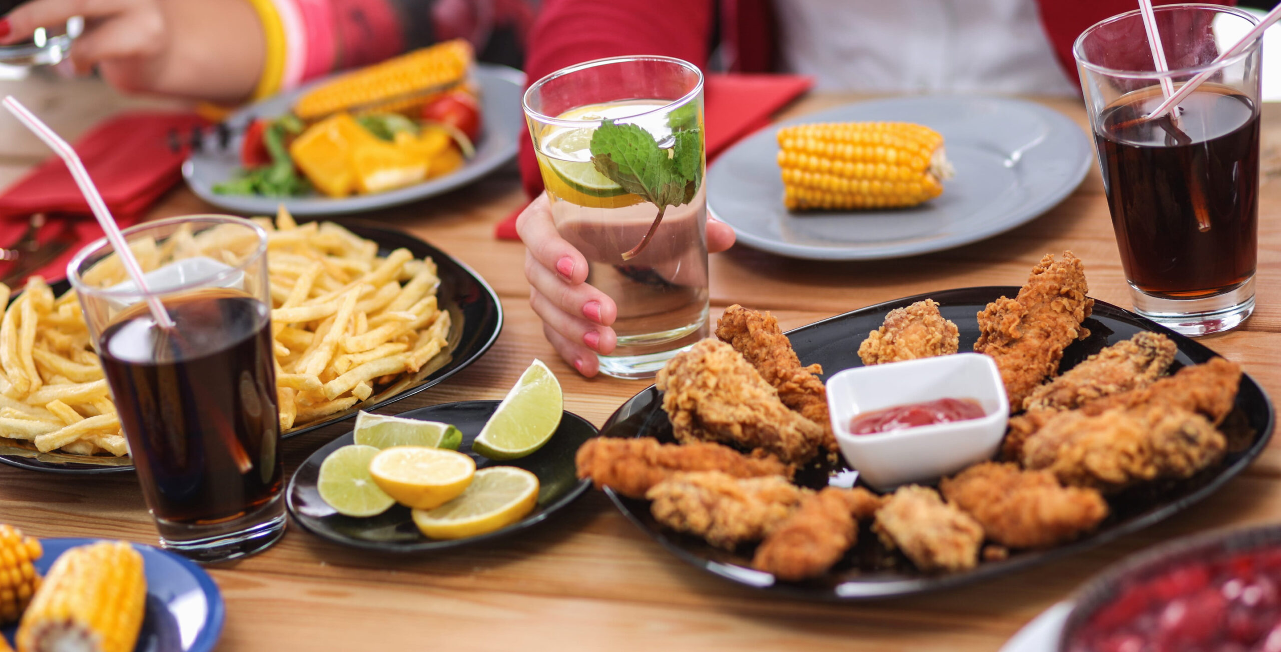 People with drinks while sitting at the dining table.
