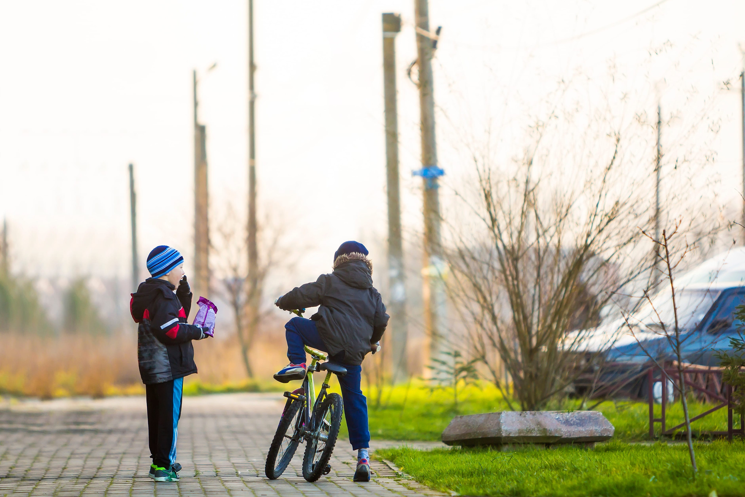 Boys friends on a bicycle outside. Children playing outdoors
