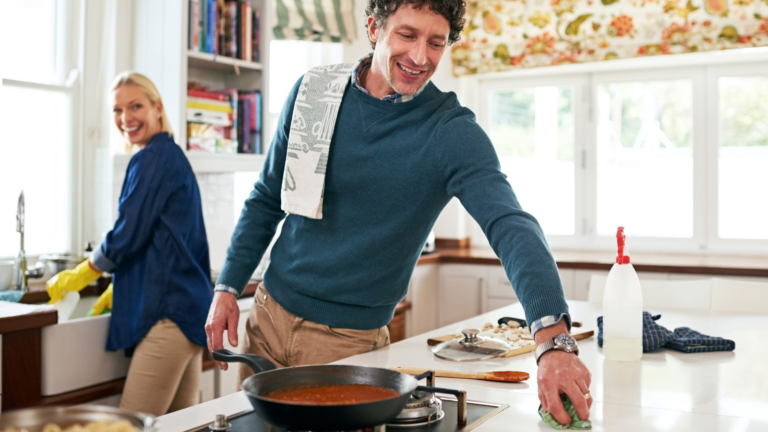 Getting a head start on the post-dinner cleanup. Shot of a happy couple cleaning their kitchen together while cooking dinner. Image Credit: peopleimages12/ 123RF