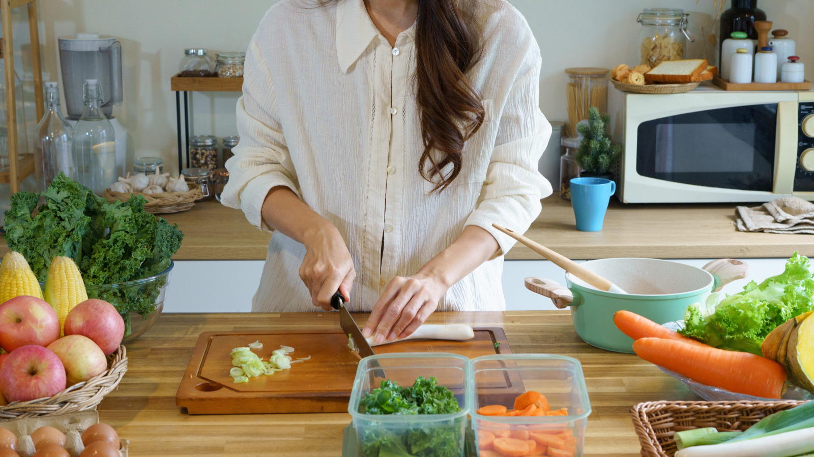 woman chopping fresh vegetables on a wooden cutting board and healthy ingredients for cooking, ideal for healthy eating, nutrition, and meal prep concepts. Image Credit: zzgooggigzz/ 123RF