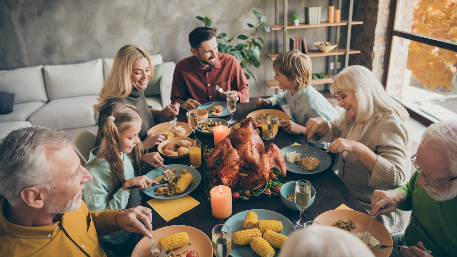 A joyful family gathering around a beautifully set table, sharing a delicious Thanksgiving feast filled with laughter, warmth, and the aroma of roasted turkey. Generations come together, creating cherished memories over a delightful meal. Image Credit: deagreez/ 123RF