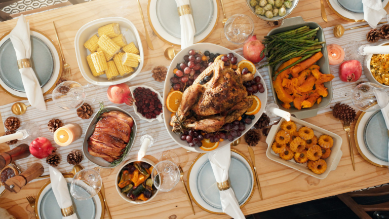 table and turkey for thanksgiving at house with food layout, health vegetables and celebration. Candles, feast and cuisine setup with wine glass, nutrition meal and lunch tradition for festive. Image Credit: peopleimages12/ 123RF