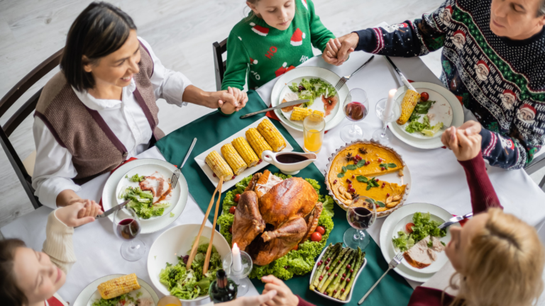 Gathered around the table, a joyful family shares a festive meal, filled with heartwarming conversation and delicious dishes, as laughter fills the air and memories are made. Image Credit: lightfieldstudios/ 123RF