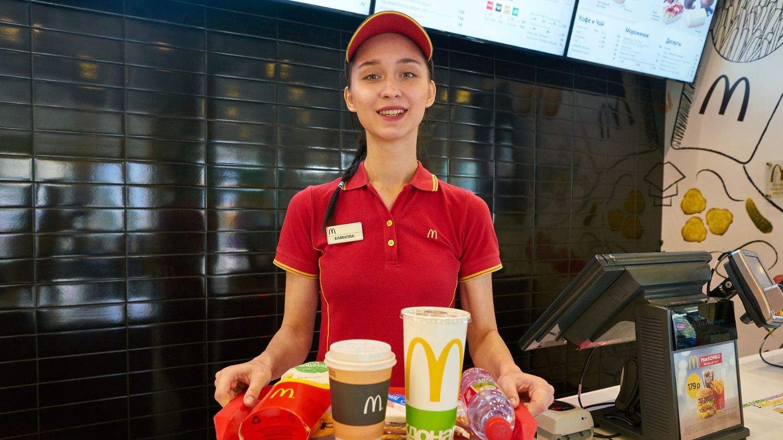 worker with food served on a tray in McDonald's restaurant. McDonald's is an American fast food company. Image Credit: tea/ 123RF