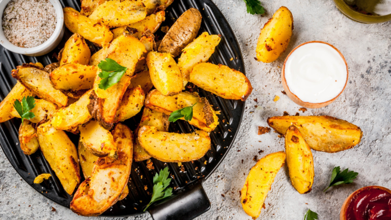 A delectable spread of golden, crispy potato wedges garnished with fresh herbs, accompanied by a variety of dipping sauces that beckon to be savored. The warm and inviting arrangement promises a delightful culinary experience, perfect for sharing with friends or enjoying during a cozy night in. Image Credit: bondd/ 123RF