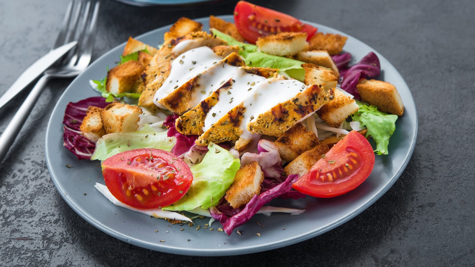A vibrant and healthy meal featuring grilled chicken atop a bed of fresh greens and tomatoes, perfectly paired with a steaming cup of coffee on the side. The combination is not just a treat for the palate, but also a feast for the eyes, making it a perfect choice for a nutritious lunch or dinner. Image Credit: dimasobko/ 123RF