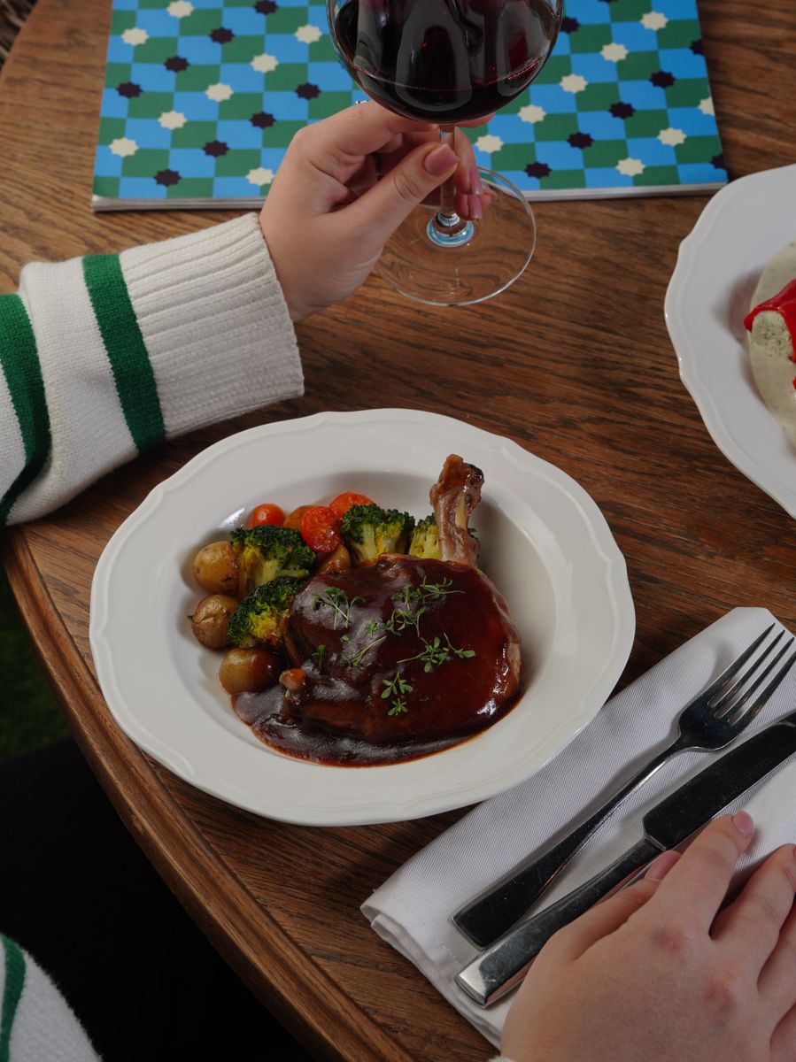 A cozy dining setting featuring wine and a gourmet roast meal.