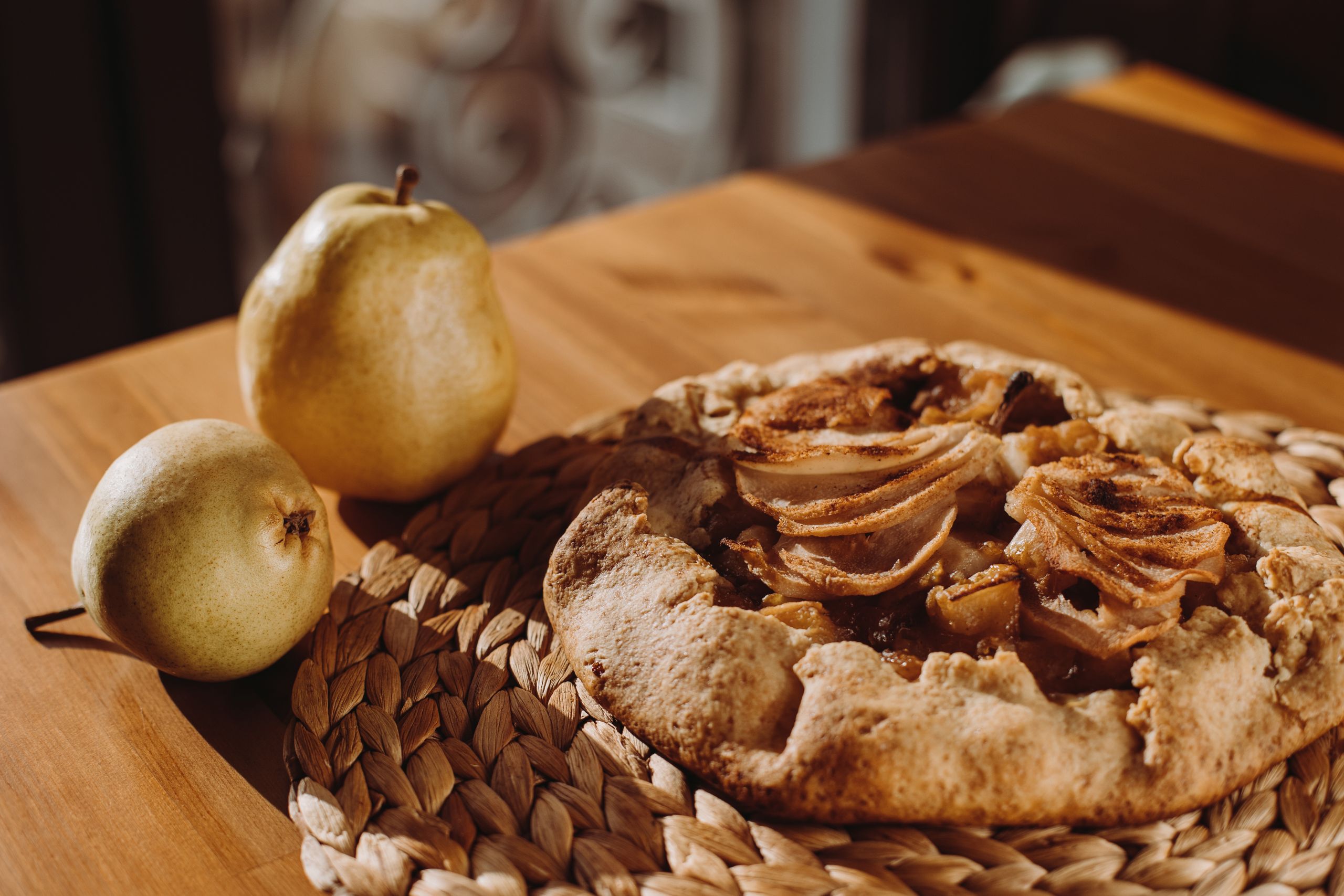 A delicious pear galette on a wooden table, embodying autumn warmth.