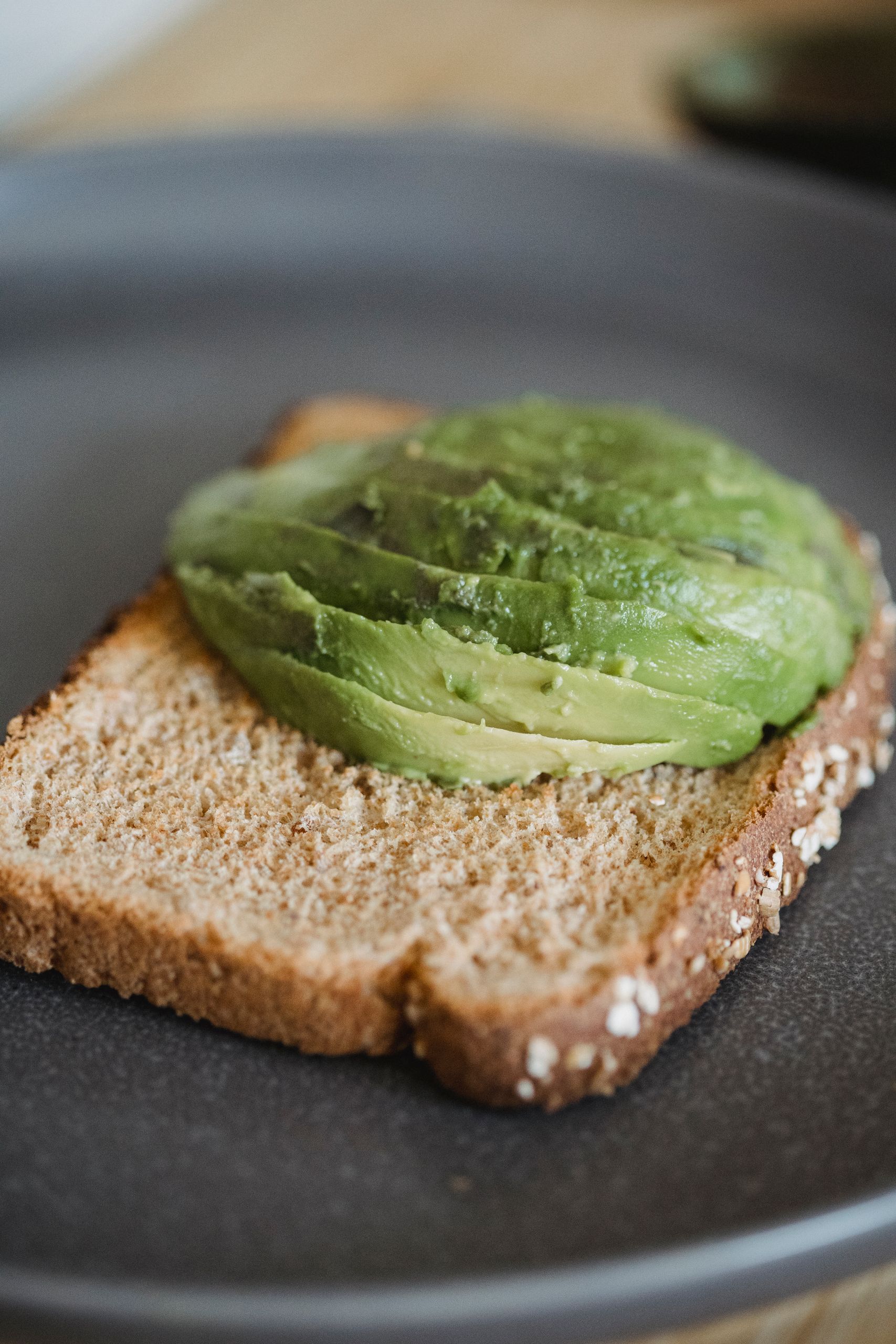 A detailed shot of sliced avocado on wholegrain toast, perfect for healthy eating visuals.